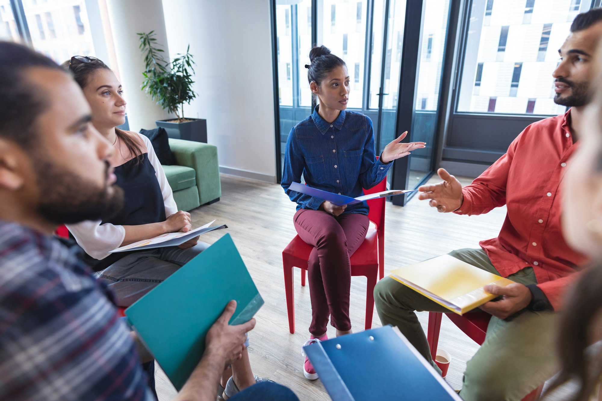 Diverse group of creative colleagues talking at casual meeting