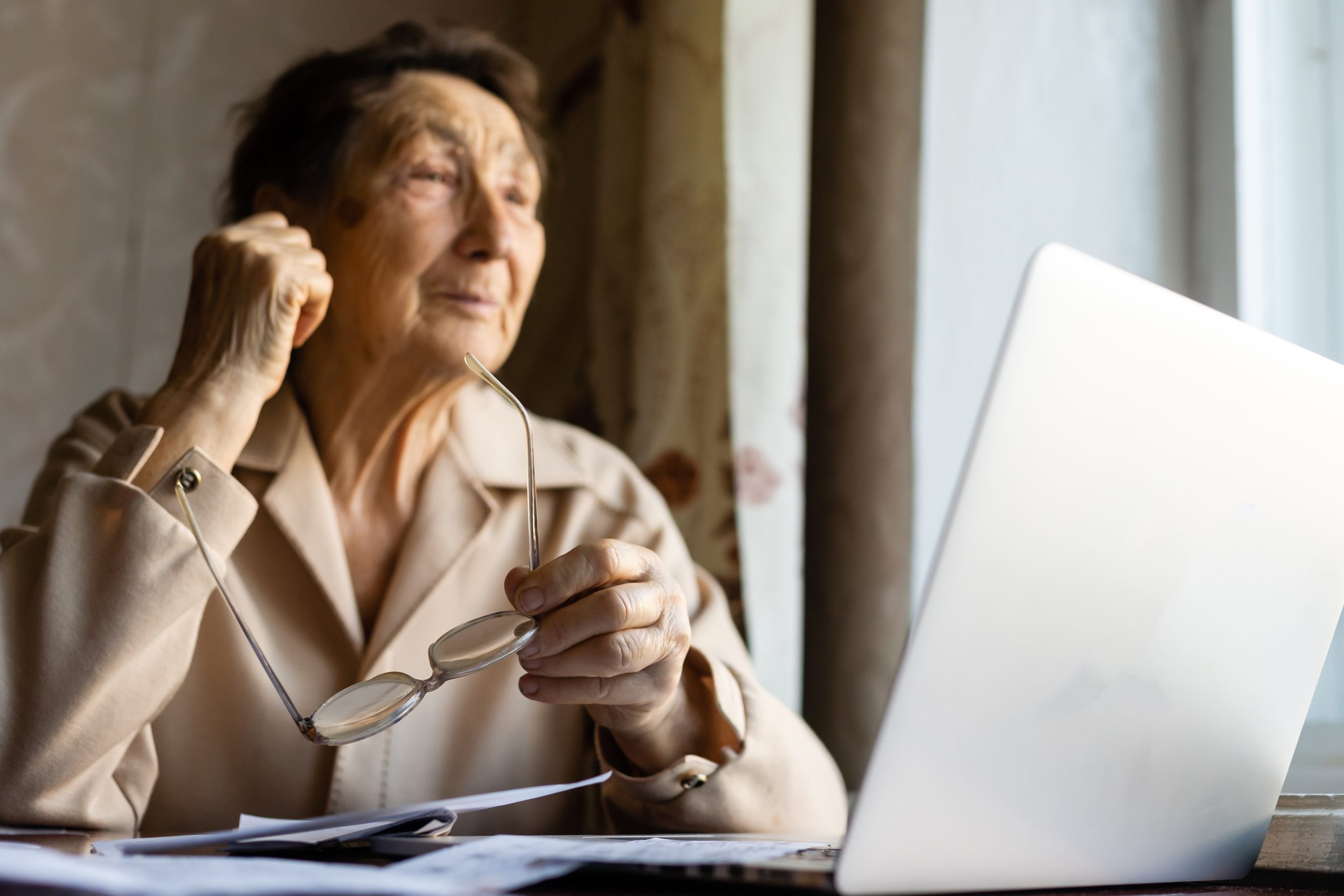 Pensioner read countless papers and is very focused. Senior woman calculating taxes at home. Retired woman calculating her domestic bills. Business, savings, annuity insurance, age and people concept